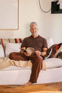 Man reading on the couch in a sunlit living room