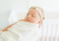 baby in white swaddle