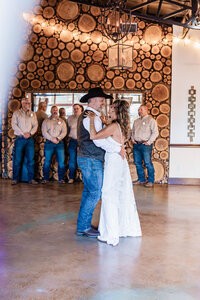 Candid portrait of a bride and groom dancing during their first dance on their wedding day at Azle Deer Cove by Graceful Ray Photography.
