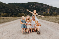 Family of six all together on a road with mountain views behind in Gatineau