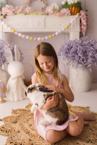 Little girl pets a live bunny during Easter Mini Session at Holy City Babies Portrait Studio in Charleston, SC.