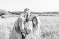 Couple laughing in a field.