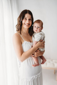Charleston Mini Sessions - Mother embraces her baby during Mother's Day Mini Session at Holy City Babies in Charleston, SC.