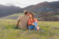 engagement photos in open field by water tower and mountain in bay area california