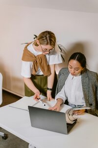 Two business woman overlooking a laptop.