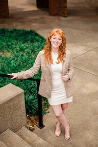 Senior headshot on the Vanderbilt campus wearing white dress with a blazer