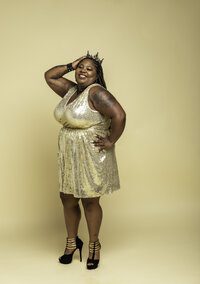 Curvy Black woman in gold dress and black heels