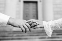 Luxury black and white photo of couple gently holding handing with engagement ring