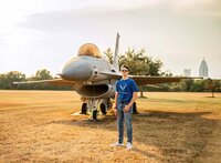 Senior portrait at Battleship Memorial Park in Mobile, Alabama— wearing an airforce t-shirt an sunglasses in front of a fighter jet.