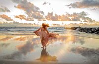 Jacksonville, FL portrait session capturing At sunrise on Vilano Beach, a graduating senior twirls in the tide’s reflection, her dress catching the breeze as pastel clouds and early light wrap the moment in quiet anticipation.