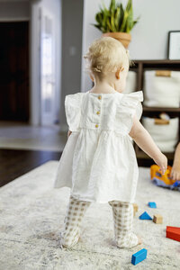 A toddler girl looks at the toys in the house