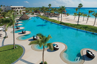 Scenic aerial view of a luxury resort with a lagoon-style pool and lush palm trees, showcasing upscale vacation experiences.