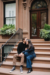 A genuine connection captured between a couple sitting on a Brooklyn brownstone stoop during their multi-day wedding celebration.