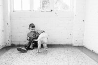 Young boy plays with new puppy on floor in Tennessee