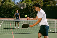 Two players mid-rally on a backyard pickleball court
