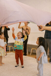 Kids having fun under a parachute at The Bunny Hive Mountain View