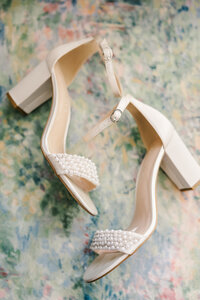 Pearl wedding heels laying on a floral background