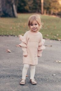 Young girl in a blush pink outfit twirling outdoors during a Cleveland family photography session