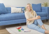 Female business owner sitting on a floor near a couch during a relaxed Ventura County brand photography session.