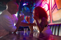 Couple toasting drinks at a bar during their downtown elopement celebration