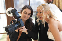 Photographer showing bride images on camera during Rochester Hills wedding photography