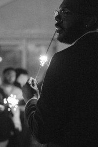groom candid suave holding sparkler in front of guests at fairview metropolitan in oakland california