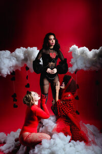 Band photographed together on a dramatic red studio set.