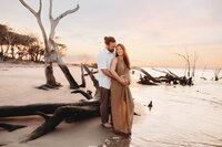 Pregnant woman poses for Maternity Portraits on Folly Beach near Charleston, SC.