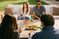 Friends gathered outside over a charcuterie board on a sunny afternoon
