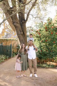 family standing and smiling at camera at gamble gardens in palo alto