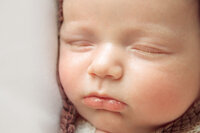 Serene newborn baby resting on soft neutral pillow in studio