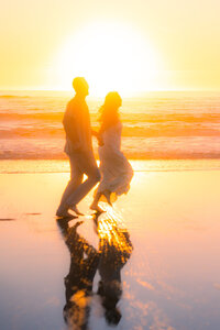 sunset beach couple running on sand barefoot in santa cruz