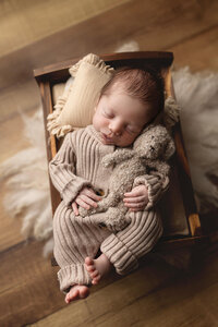 Baby boy asleep with a teddy bear during his baby photo session at Jennifer Brandes Photography outside of New Ulm, Minnesota.