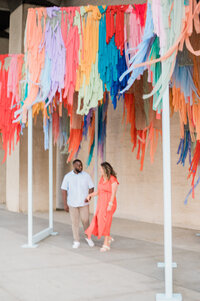 Couple stands under colorful decoration in the Upper West Side