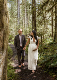 Couple walking through the Mount Hood Forest for a Maternity Photoshoot