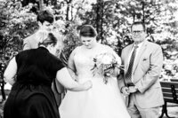 Mahlia fixing brides dress during family photos