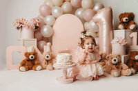 Charleston Cake Smash Photographer- Baby looks into the camera during Cake Smash Photos at Holy City Babies Portrait Studio in Charleston, SC.