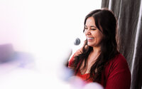 Musician laughing beside a microphone during an intimate singer-songwriter branding session