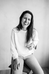 Zwart/wit portret van lachende ondernemer op kruk - branding fotografie alkmaar