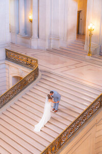 wedding couple kiss on stairs at san francisco city hall wedding