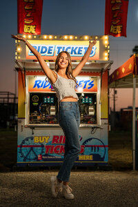 Senior portrait at the Greater Gulf State Fair in Mobile, Alabama — arms raised in front of a
ticket booth.