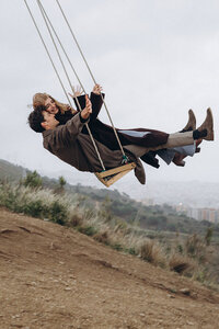 Artsy and joyful couple photoshoot on a swing in Barcelona, emphasizing movement, laughter, and authentic storytelling.