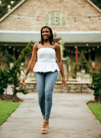 Senior portrait at Bella Sera Gardens in Loxley, Alabama — walking down a courtyard path with
the main fountain in the background.