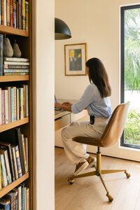 Woman working at a desk in a sunlit home office