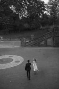 An engaged couple running through Bethesda Terrace in Manhattan.