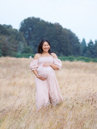Discovery Park maternity session in Seattle - mom is walking happily in a grassy field