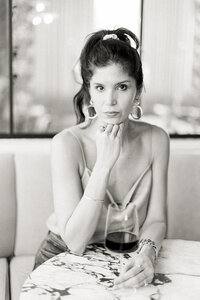 Professional headshot of a Dallas/Fort Worth business owner holding a glass of red whine as she poses for the Dallas brand photographer.