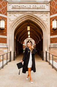 Vanderbilt senior wearing grad attire at Vandy tower