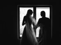 backlit black and white editorial bride getting ready with a friend