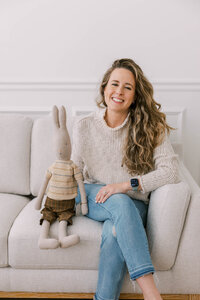 Woman sitting on a loveseat at The Bunny Hive